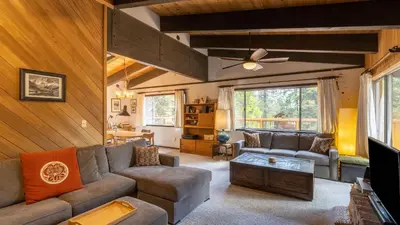 a living room with a couch and a tv at Fawn by AvantStay Secluded Cabin w Large Deck Surrounded by Forest in Tahoma Meadows