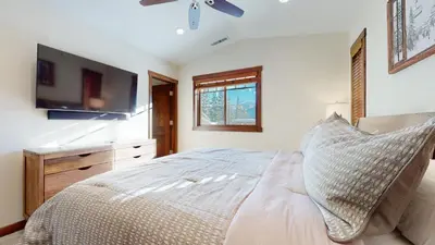 a bedroom with a bed and a flat screen tv at Lakeview Townhomes #5 townhouse in Mammoth Lakes