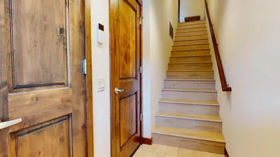 a hallway with a wooden door and stairs at Lakeview Townhomes #5 townhouse in Mammoth Lakes