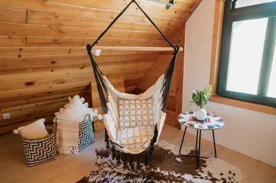 a hammock in a room with a wooden wall at Romantic Forest Lovers Nest by Casa Oso in Mariposa