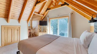 a bedroom with a bed and a large window at Ember by AvantStay Majestic Entertainers Home w Pine Tree Views Close to Meeks Bay in Tahoma Meadows