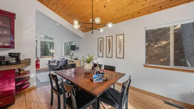 a kitchen and dining room with a wooden table and chairs at Moosetrack by AvantStay Cozy Cabin w Hot Tub In The Heart of Tahoe Donner in Truckee