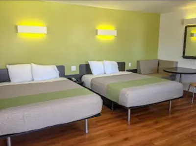 a room with two beds and a table at American Inn in Hawthorne