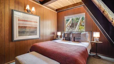 a bedroom with a bed and a window at Horizon by AvantStay Stunning A-frame Cabin w Hot Tub Billiards Lake Views in Tahoe City