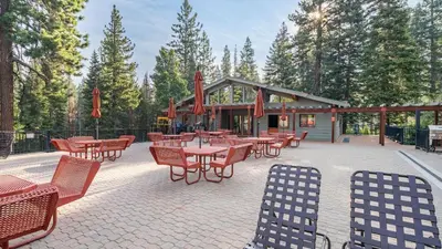 a patio with tables and chairs in front of a building at Sockeye by AvantStay Modern 2 BR Condo w Access to Northstar Resort Community in Kingswood Estates