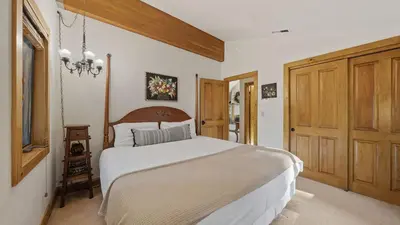 a bedroom with a large bed and a wooden door at Ellis Peak by AvantStay Beautiful McKinney Cabin w Filtered Lake Views in Homewood