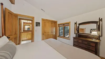 a bedroom with a large bed and a mirror at Ellis Peak by AvantStay Beautiful McKinney Cabin w Filtered Lake Views in Homewood