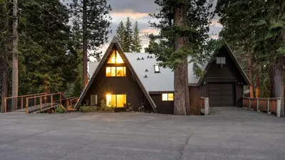 a house with a gambrel roof with a garage at Timberline by AvantStay Stunning Chalet Cabin w Hot Tub Pool Table Home Theater in Tahoe Vista