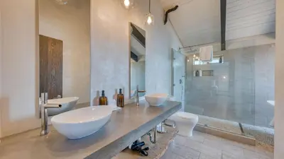 a bathroom with two sinks and a shower at Lakeview by AvantStay Private Waterfront Cabin on Lake Tahoe w Hot Tub Views in Tahoe Vista
