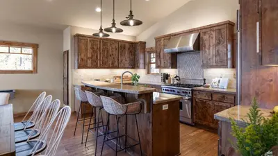 a kitchen with wooden cabinets and a large island with bar stools at Lakefront Home in Kings Beach w Views • Prime Location Atkinson by Avantstay in Tahoe Vista
