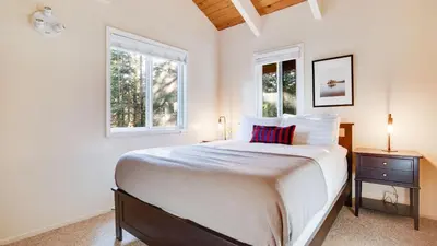 a bedroom with a large bed and two windows at Hot Tub Sauna Game Room Modern 5BDR Family Cabin Homewood by AvantStay in Tahoma Meadows
