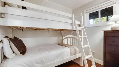 a bedroom with two bunk beds and a ladder at Hot Tub Sauna Game Room Modern 5BDR Family Cabin Homewood by AvantStay in Tahoma Meadows