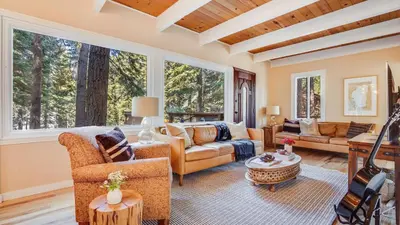 a living room with furniture and large windows at Hot Tub Sauna Game Room Modern 5BDR Family Cabin Homewood by AvantStay in Tahoma Meadows