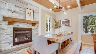 a living room with a fireplace and a table at Hot Tub Sauna Game Room Modern 5BDR Family Cabin Homewood by AvantStay in Tahoma Meadows