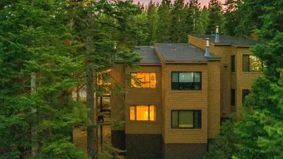 a house in the woods with the lights on at Ski-InSki-Out Access to Northstar Resort Near Truckee Sierra by AvantStay in Kingswood Estates
