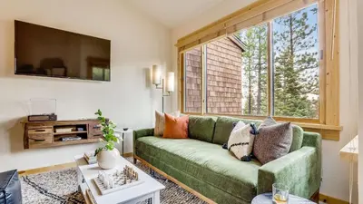 a living room with a green couch and a large window at Ski-InSki-Out Access to Northstar Resort Near Truckee Sierra by AvantStay in Kingswood Estates