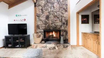 a stone fireplace in a living room with a tv at Wolfe by AvantStay 5mins NorthStar Fireplace 2 Private Decks in Ponderosa Fairway Estates