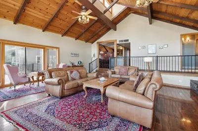 a living room with leather furniture and a wooden ceiling at Dos Pinos Spacious Lakefront Cabin with Game Room in Groveland