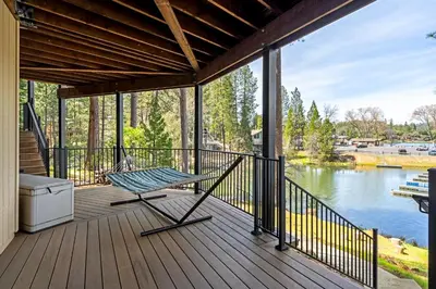a porch with a hammock and a view of a lake at Dos Pinos Spacious Lakefront Cabin with Game Room in Groveland