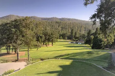 a view of a golf course with a green at Dos Pinos Spacious Lakefront Cabin with Game Room in Groveland
