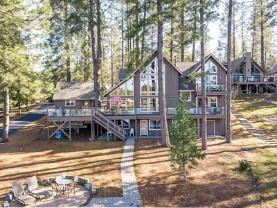 a large house in the woods with a deck at Lakefront Casa Cassaretto in Groveland