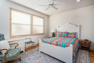 a bedroom with a bed and a chair and a window at Lakefront Casa Cassaretto in Groveland