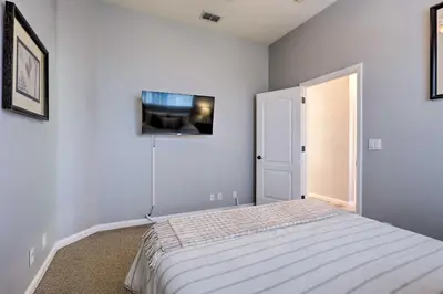 a bedroom with a bed and a tv on the wall at Spacious Folsom Getaway with Pool and Hot Tub! in Folsom