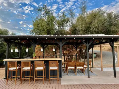 a wooden gazebo with chairs and a table at Boho chic oasis by Casa Oso with pool, spa and views in Ahwahnee