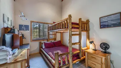 a bedroom with a bunk bed and a desk with a desk at Wolfs Lair by AvantStay Swiss Chalet w Private Hot Tub Access to Northstar Resort Community in Kingswood Estates