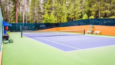a tennis court with a net on top of it at Zephyr by AvantStay Stylish Modified A Frame w Access To Tahoe Donner in Truckee
