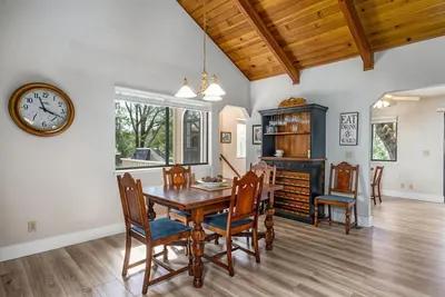 a dining room with a table and chairs and a clock at 3 Wild Turkeys Family Friendly Home in Groveland