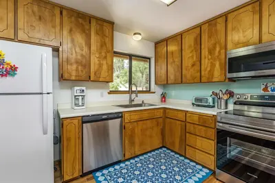 a kitchen with wooden cabinets and a refrigerator at The Happy Place Mountain View Home in Groveland