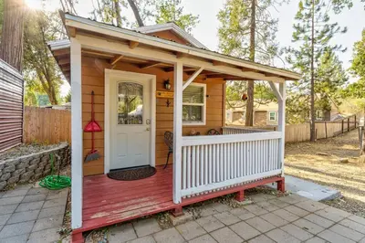 a tiny house with a porch and a white door at Acorn Cottage - Hidden gem in green heaven, getaway to Bass Lake & Yosemite in Oakhurst