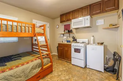 a small kitchen with a bunk bed and a white refrigerator at Acorn Cottage - Hidden gem in green heaven, getaway to Bass Lake & Yosemite in Oakhurst