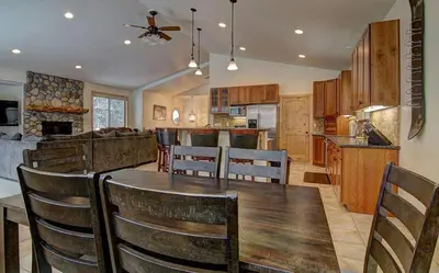 a kitchen and dining room with a wooden table and chairs at Lukins Lodge By The Lake Hot Tub in South Lake Tahoe