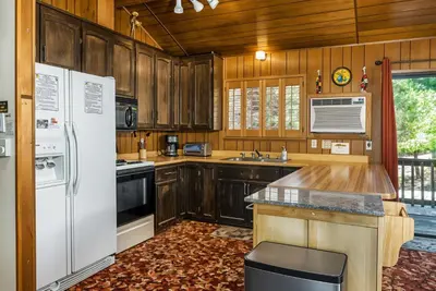 a kitchen with wooden cabinets and a white refrigerator at Pet Friendly The Hideout Yosemite Home in Groveland