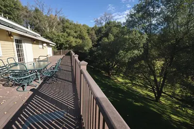 a balcony with a table on a fence at Yosemite Villa - Only 0,3 Miles from Lake Lodge Beach and Playground in Groveland