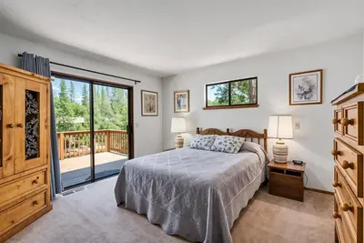 a bedroom with a bed and a balcony at The Big Easy Lakefront Cabin in Groveland