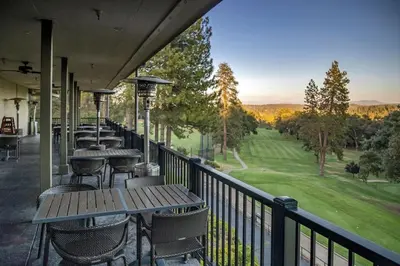a row of tables and chairs on a balcony with a view at The Big Easy Lakefront Cabin in Groveland