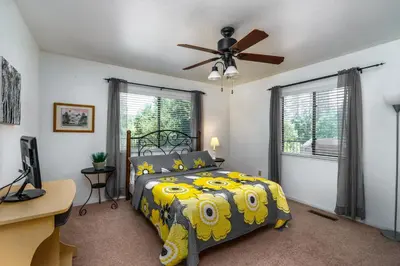 a bedroom with a bed and a ceiling fan at Rustic Modern Cabina De Alba in Groveland