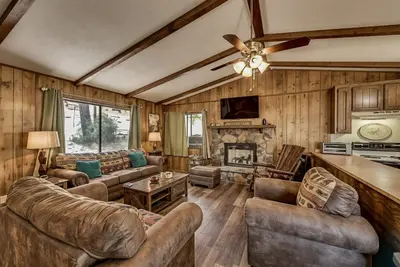 a living room with leather furniture and a fireplace at Pet Friendly Grizzly Blair Lodge Cabin in Groveland