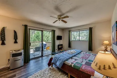 a bedroom with a bed and a ceiling fan at Pet Friendly Grizzly Blair Lodge Cabin in Groveland