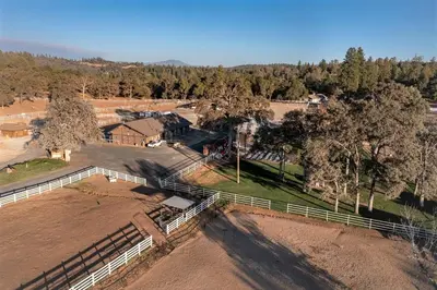 an aerial view of a farm with a fence and trees at Pet Friendly Grizzly Blair Lodge Cabin in Groveland