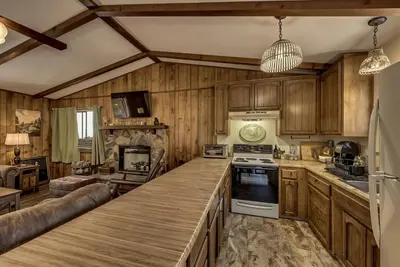 a kitchen with wooden cabinets and a large counter top at Pet Friendly Grizzly Blair Lodge Cabin in Groveland