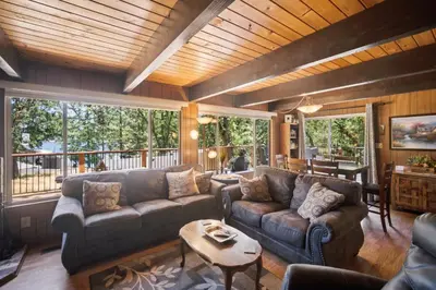 a living room with couches and a table at Lakefront Cozy Cabin on the Cove in Groveland