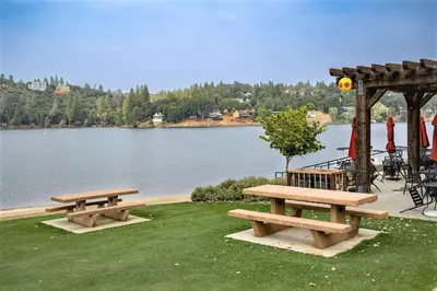 two picnic tables and a gazebo next to a lake at Star of the Mountain Yosemite Home in Groveland