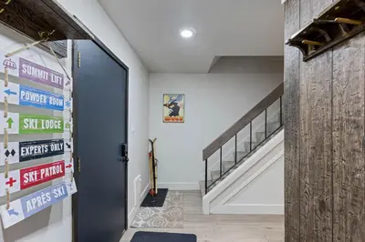 a hallway with a staircase and a door with signs on it at Luxurious 2 Bedroom Base Camp Condo - Steps from Kirkwood Village condo in Kirkwood