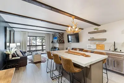 a kitchen and living room with a table and chairs at Luxurious 2 Bedroom Base Camp Condo - Steps from Kirkwood Village condo in Kirkwood
