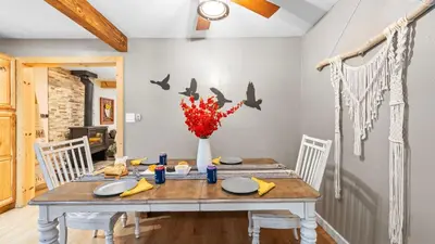 a dining room with a table with birds on the wall at Sweet Pine Deck Hot Tub Cozy Modern Interior Close to Ski Resort in Pomins