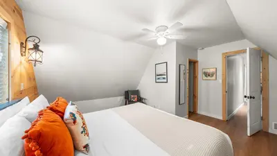 a bedroom with a white bed and a ceiling fan at Sweet Pine Deck Hot Tub Cozy Modern Interior Close to Ski Resort in Pomins